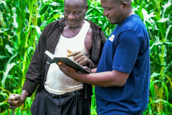 image of an extension worker training a farmer